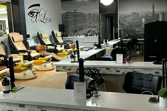 Pedicure lounge with spa chairs beneath the J.Lon eye logo and a Las Vegas skyline mural