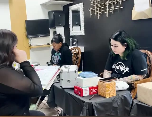 Academy students practicing lash work around a training table